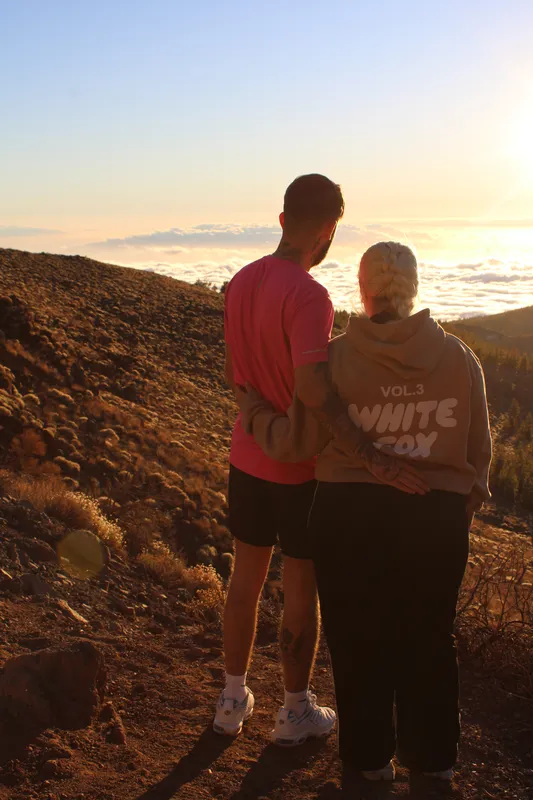 Portrait of happy couple posing on a double quad bike above clouds